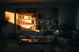 Illustration von einer Hand, die eine Glühbirne über einen unordentlichen Raum hält, aus der Lichtstrahlen wie Regale und Trennwände in die Unordnung scheinen und diese sofort in geordnete, klar definierte Zonen verwandeln.